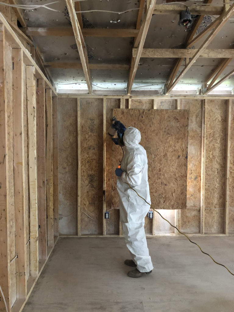 Sapphire Restoration technician in protective gear inside a contained work area