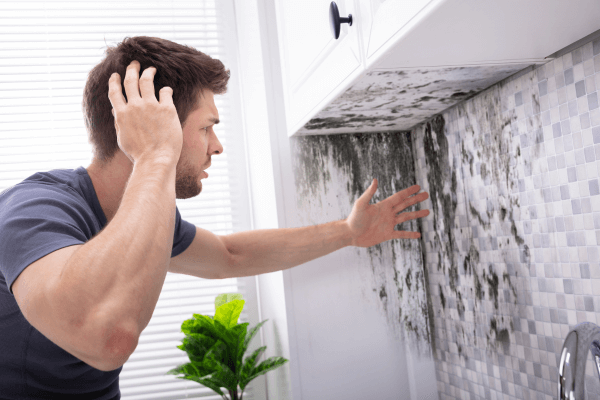 man wondering how to get rid of black mold on his wall