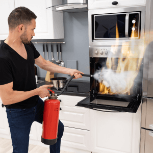 man using fire extinguisher for oven fire