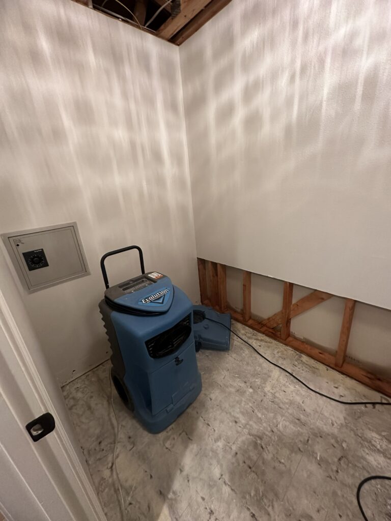 Commercial dehumidifier drying a bathroom after flood cut and mold removal